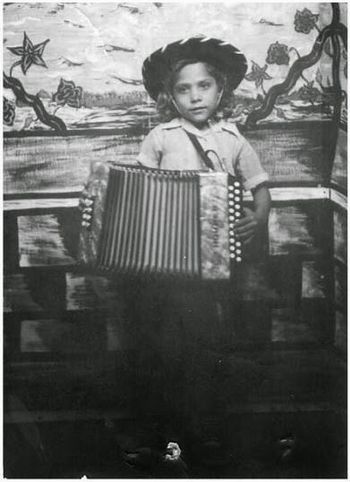 Photo of a young Eva Ybarra posing with her accordion taken in Arizona. In her youth, the family would travel to the agricultural fields for work. While in Arizona, Ybarra would play around town with her brother, Pedro Jr., accompanying her on bajo sexto.
