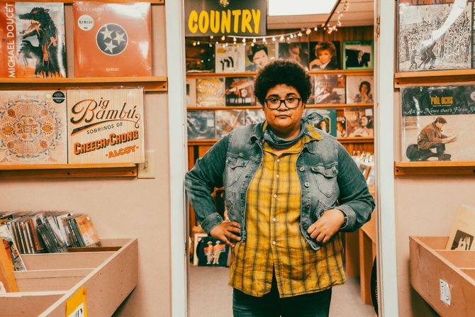 Autistic musician Jen Msumba stands in Banana Records among hundreds of vinyl records