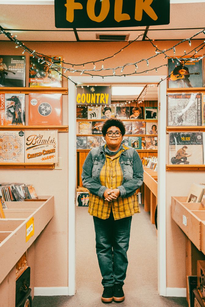 Autistic musician Jen Msumba stands in Banana Records among hundreds of vinyl records