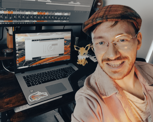 Cataldo Cappiello taking a slightly blurry selfie in front of his DAW displaying an instance of Spitfire Audio's LABS plugin. Cataldo is wearing a flat cap, rimless glasses and a pink shirt.