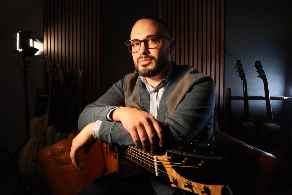 GUITARIST MICHAEL WATTS HOLDS A KOSTAL ACOUSTIC GUITAR