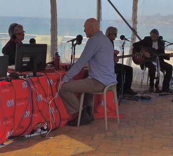 Linda Mottram, Peter Garrett, Peter O'Doherty and Reg Mombassa playing at Coogee Beach.
