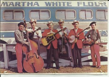 Color Photo of Flatt & Scruggs in front on one of their tour buses.
