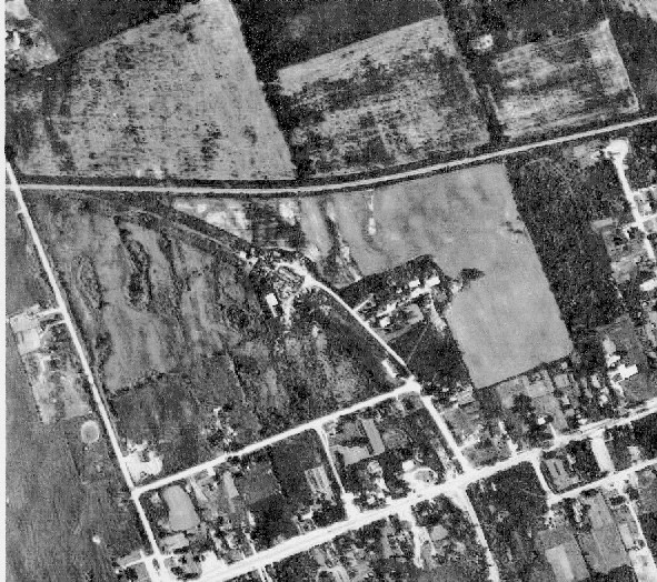 Aerial photo 1950s, Omemee Junction. The former roadbed north of King St. (Hwy 7) curves northwest on the west side of Deane St. North, and the former elevator is approximately two-thirds of the way between King St. and the junction itself. The site of the former junction station foundation is also apparent in the gore between the two roadbeds east of the junction. Courtesy Larry Murphy