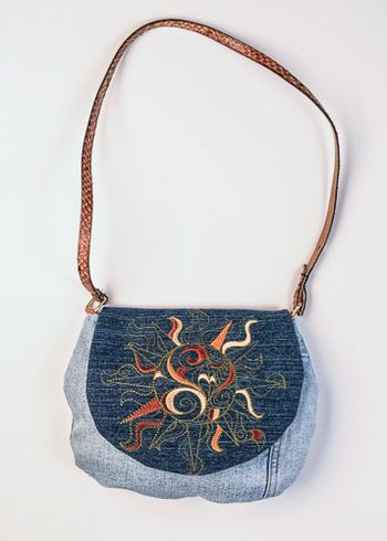 Sun embroidered on upcycled denim. The strap is a belt.
