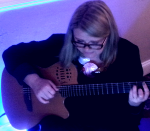 Our Guitarist, Carole, lit by one of our colour-changing lights