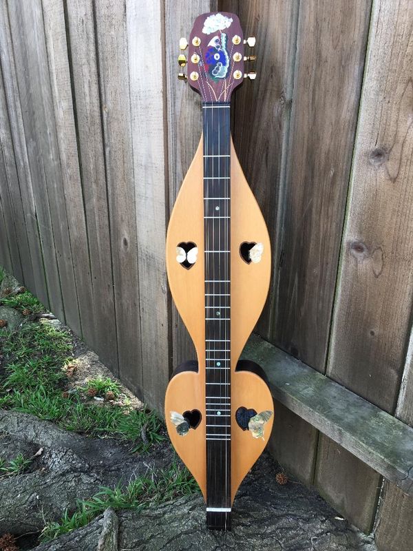 Butterfly Dulcimer by Joellen Lapidus
East Indian Rosewood sides and Back, European Spruce Top, 28.5" fretscale with ebony overlay, Peghead and Soundholes inlayed with mother of pearl, red, green and black abalone
Comes with a custom hard shell case.