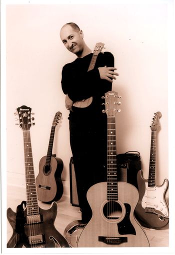 Promo photo done around the time of my album Chasing After Light.  I still use the Taylor acoustic steel string, but I only used the Ibanez a little and then sold it to a student.  I kept that strat for a long time, but ultimately it started gathering dust when I started playing Ernie Ball guitars, and last year I sold it.
