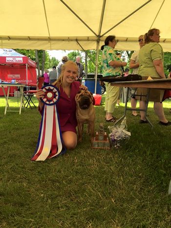 Corleone posing with handler Karyna Cazelais and the 2015 Canadian Nationals Trophy, Ribbon, and Prizes
