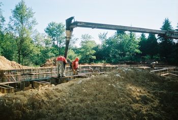 concrete is pumped into wall forms from a large truck
