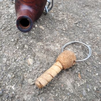 An old wine cork with a salvaged ring and a wood plug for the mouth part.
