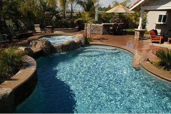 Pool with rock formation and pebble tech, completed new construction.

