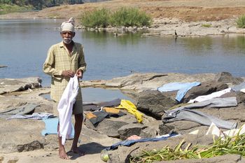Elegant man doing laundry in the Tansa River
