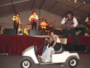 2006-It's hard to compete with Keith during the "Orange Blossom
Special." Ken jumped on the back of this cart during his
harmonica solo and had them drive through the pavilion. You
can't blame them for looking a little baffled
