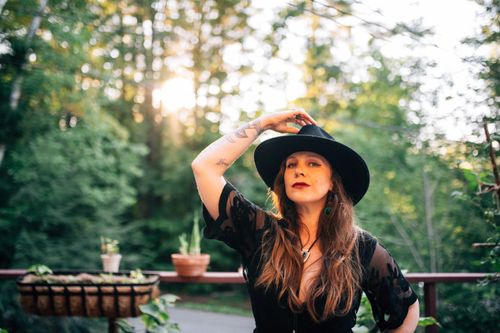 Portrait of Americana singer/songwriter Sarah King outside wearing black hat