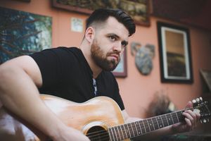 Greg Owens with an acoustic guitar