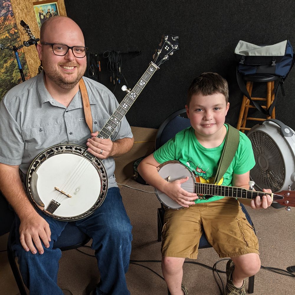 Photo of Jim with a student during a banjo lesson at Bill's Music Shop