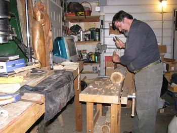 Dave at carving bench skinning a log
