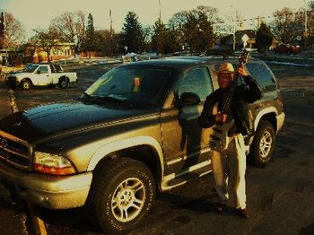 Hubert Temba with bass guitar next to his beloved SUV on December 28, 2008. Photo by Ron Plaman. (Al
