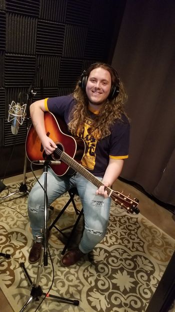 Caleb Lake recording an acoustic guitar track.
