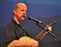 Les Thompson plays his banjo in front of a beautiful Blue Ridge scene