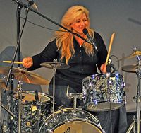 Lisa Taylor smiles while playing her late father's drum set