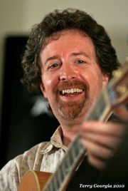 Andrew McKnight closeup smiling with guitar