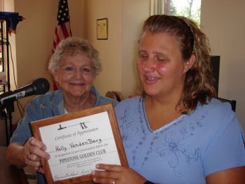 Holly accepting a certificate from The Golden Club, Perdita Douty
