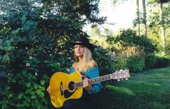 Roberta with acoustic guitar in garden
