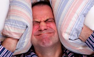 Image of man trying to block out noise with pillows