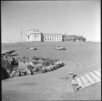 Showing an exterior view of Auckland Museum, with the semi-circular extension at the rear under construction 1957

