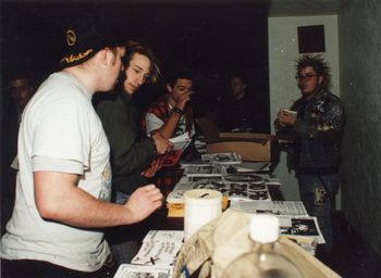 Merch and distro table @ the Capitol Theater (in the fallout shelter), March, 1991. In the foreground is Ronin and Ninja High School vocalist Cory Robinson (RIP). Photo by and courtesy of Ace Morgan © 1991. https://www.facebook.com/acemorganphoto/
