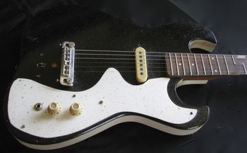 Sears Silvertone guitar With make-shift gold-fleck formica pick guard and replacement bridge and pickup. It's in rough shape.
