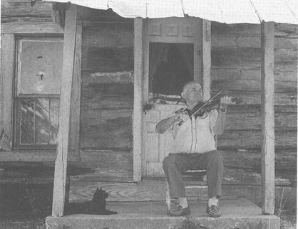 Lotus Dickey on porch of his cabin