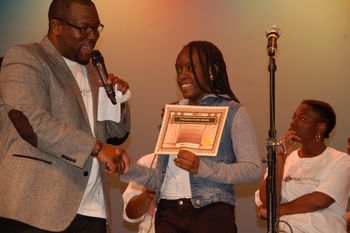Mr. Williams presents certificate to performer from local youth group
