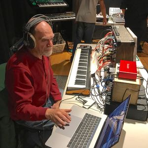 Image of: MW Gilbert seated at synthesizers