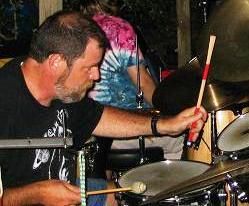 EMIT's president and drummer Jim Stewart performing with PoOg at Sacred Grounds.
