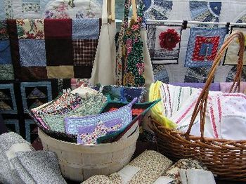 Pot holders, receiving blankets, table runners, aprons, placemats and napkins - just some of my handiwork that I sell at the Farmers Market.  Photograph by Cynthia Nousak a friend and vendor.
