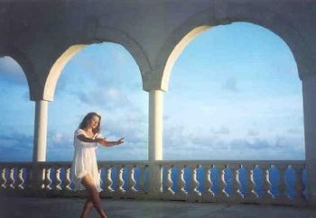 Framed between the archways and blue Caribbean sky backdrop on the island of Canaun in the South Caribbean. Bethany relaxes with some ballet stretches during a day off from performing her show. (Photo
