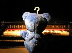 the blue bear seated at the piano