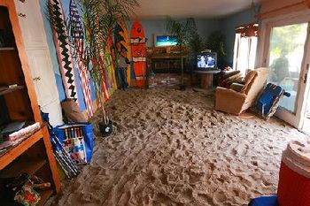 This is Erin Fritz's actual living room and Yes, that is sand, and those are plywood surfboards screwed to the walls
