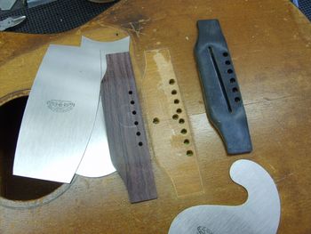 I cut a new bridge from rosewood, and prepared the mounting surface on the guitar's top....
