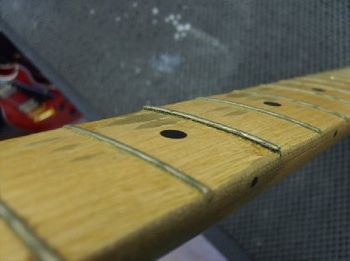 carefully removing the frets without disturbing the fretboard itself
