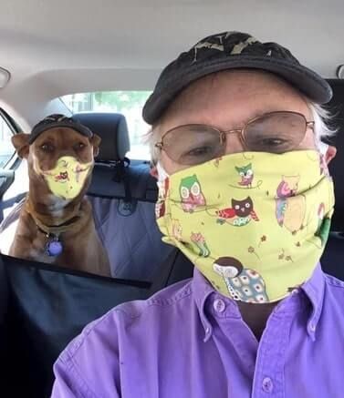 Humorous Motivational Speaker Greg Tamblyn and his dog Houdini wearing covid masks in car.