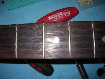 Complete re-fret required! Good opportunity to sand the gouges out of the fingerboard.
