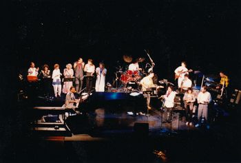 'THE WHOLE CREW' Morry Stearns & Friends Concert, Royal Theatre 1987. Guest performers: Valdy, Shari Ulrich, & Paul Horn. From left: Duncan Meiklejohn, Mary Saxton, Corlynn Hanney, Joni Bye, Warren Stanyer, Mark LaFrance, Shari Ulrich, Daryl Bennett, Dane Deviller, Paul Horn, Rene Worst, Tom Colclough, April Gislason, Valdy, Bill Sample, Norm MacPherson, Morry at the Grand Piano (Bob Benson on sound)
