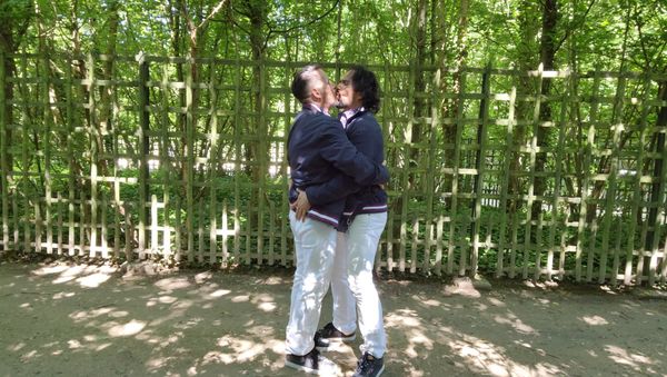 Sidow Sobrino kissing husband Richard in the Gardens of The Palace of Versailles