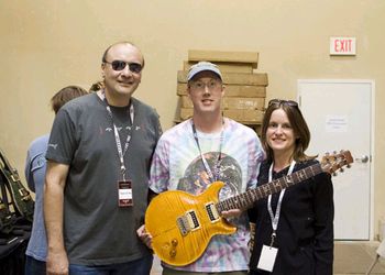 Mark DeMeno holds Carlos Santana's guitar--the first that Paul Reed Smith built for the musician. Pictured with Andrea Iglar and Frank DeFina, PRS vice president of sales/operations.
