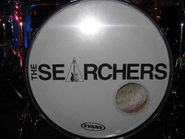                             2010
When I joined The Searchers, I was using a Pearl Masters in midnight blue fade with a plain white skin.
After discussions with the band, they told me I could have what ever skin I wanted and if I wanted to put their logo on there, brilliant!
This was my first Searchers skin. It was made by Chris, who does our CDs. The logo is the logo used on the back of our CDs with Johns distinctive 12 string guitar as the A.
Sadly it was made on the 'piss' but was replaced by a better version a few months later.