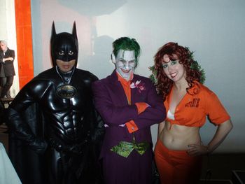 All smiles with The Joker, as Two Face lurks beind.
